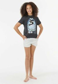 Zwarte katoenen t-shirt met een grafische print van blauwe bloemen en een landschap. Gepaarde met lichte denim shorts met franjes.