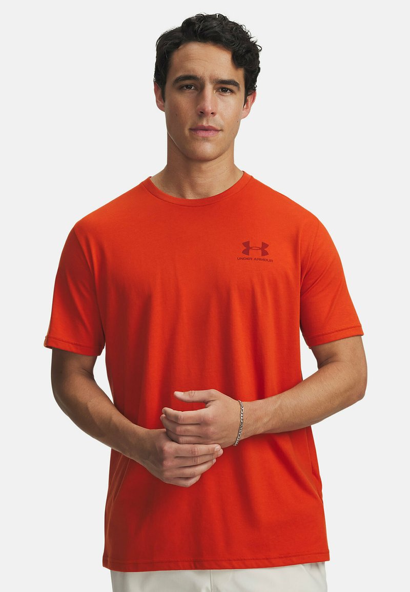 Camiseta corta de manga roja hecha de algodón con cuello redondo. Presenta un pequeño logo negro en el pecho y un corte relajado.