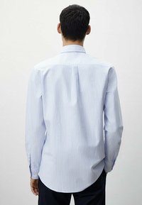 Lichtblauw gestreept overhemd met lange mouwen, knoopsluiting kraag, gebogen zoom en subtiele textuur. Zichtbare stiksels en manchetten.