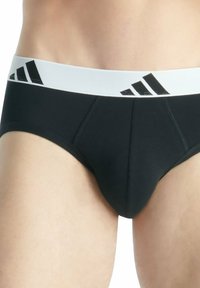 Zwarte boxershorts met een witte elastische tailleband met daarop het zwarte Adidas-logo en drie strepen. Gladde stof met versterkte naden.