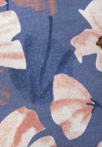 Modrá látka s veľkými ružovými kvetinovými vzormi, s jemnou textúrou a jemným ryhovaním, ktoré vytvárajú mäkký a hmatateľný povrch.