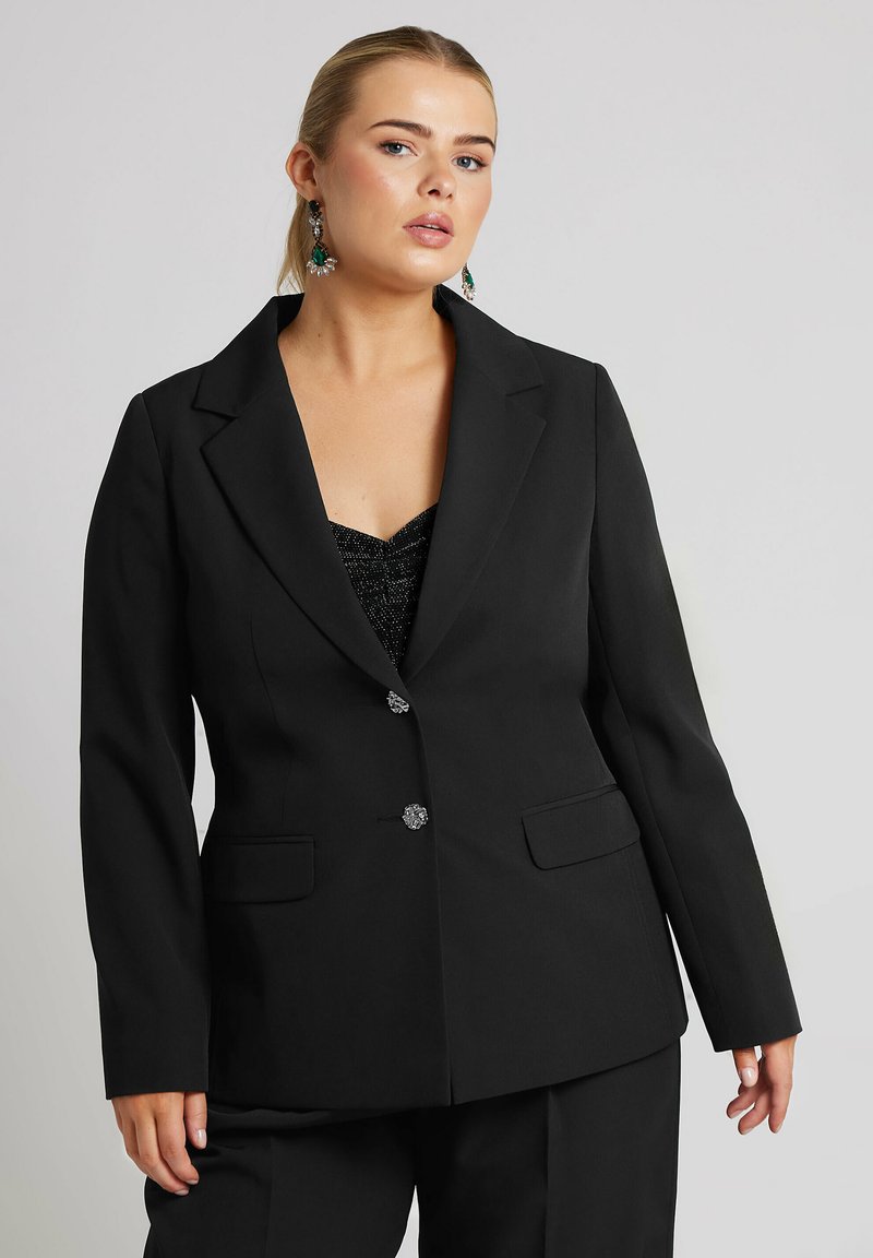 Svart kavaj med dockade slag, enkelknäppt design, två framfickor och silverdetaljer på knapparna. Skräddarsydd passform för en strukturerad look.