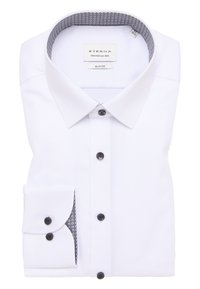 Weiße Slim-Fit-Bluse aus strukturiertem Stoff. Mit einer gemusterten Krageninnenseite und schwarzen Knöpfen, sowie einem Detail mit Ein-Knopf-Manschette.