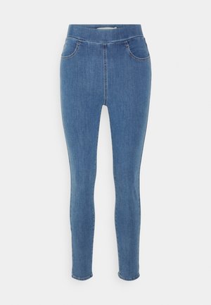 Jeggings de denim azul con una textura suave, cintura alta, diseño de cinco bolsillos y piernas ajustadas. Largo estándar con un dobladillo liso.