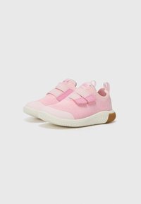 Ljusrosa sneakers med ett ventilerande stickat överdel, kardborreband och en vit gummisula med en texturerad brun accent.