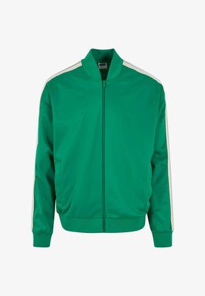 Zielona kurtka sportowa z zamkiem z przodu, stójką, kieszeniami bocznymi i białymi paskami na ramionach. Wykonana z gładkiego, lekkiego materiału.