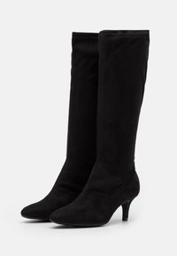 Schwarze kniehohe Stiefel aus weichem Wildleder, mit spitzer Schuhspitze und schlankem Absatz, mit einer glatten Textur und klarem Design.