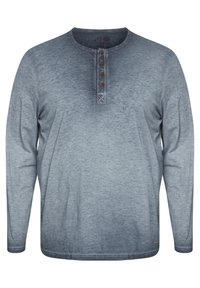 Hedvábná košile s dlouhými rukávy v šedém gradientním odstínu. Disponuje henley výstřihem s pěti hnědými knoflíky a jemnou strukturou po celém povrchu.