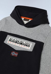 Sweatshirt à capuche bleu marine et gris avec un patch frontal, arborant le logo "Napapijri" et un petit détail du drapeau de la Norvège au niveau de la poitrine.