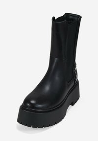 Black ankle boot with a sleek leather upper, elastic side panels, chunky platform sole, and decorative hardware detail.