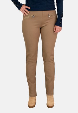 Pantalones ajustados beige con una textura suave, que cuentan con dos bolsillos frontales con cremallera y un diseño de pierna estrecha.