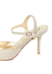 Glittering silver high-heeled shoe with a textured upper, a buckle strap, and a glossy insole. Features a pointed toe and a cushioned footbed.