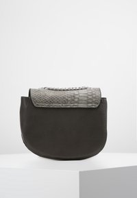 Szara skórzana torebka o zaokrąglonym kształcie, z teksturowanym klapkiem imitującym skórę węża oraz łańcuszkowym akcentem u góry. Gładkie wykończenie całości.