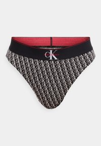 Μαύρο στρινγκ Calvin Klein με επαναλαμβανόμενο μοτίβο λευκού λογότυπου "CK", με στενή μαύρη ελαστική μέση και κόκκινη επένδυση ως διακριτικό χρώμα.