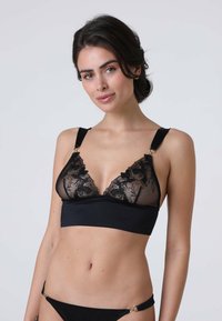 Bralette in pizzo nero con coppe triangolari morbide, design floreale e spalline in satin regolabili. Presenta dettagli in metallo dorato.