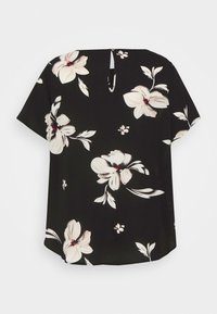 Blouse noire à manches courtes avec un grand imprimé floral blanc et une petite ouverture goutte dans le dos, fermée par un bouton.
