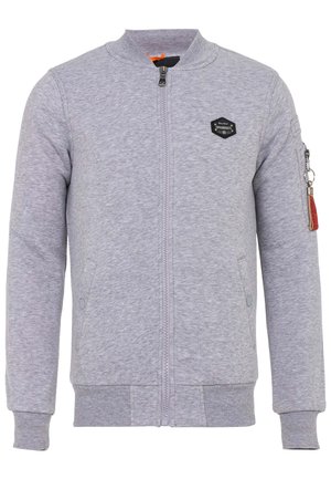 Grijze sweatshirt met een rits aan de voorkant, ribgebreide manchetten en zoom, zijkeuzen en een patchaccent op de linker borst. Heeft een rits op de mouw.