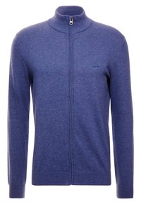 Sweter na zamek z teksturowanej ciemnoniebieskiej tkaniny, z wysokim kołnierzem i ściągaczami na rękawach. Subtelne logo marki na piersi.
