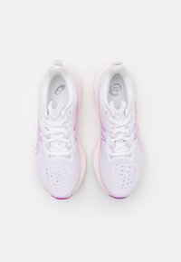 Weiße Sportschuhe mit pinken Akzenten, strukturiertem Mesh-Obermaterial, runder Zehenpartie und flachen Schnürsenkeln. Sichtbare Perforationen für Atmungsaktivität.