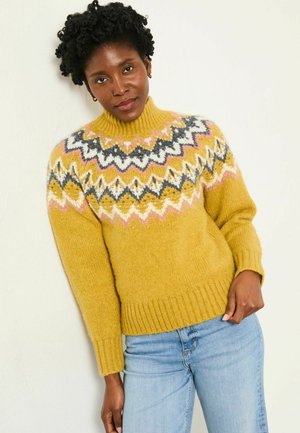 Gelbes gestricktes Sweatshirt mit hohem Kragen, das ein geometrisches Farbenspiel in Grau, Weiß und Rosa zeigt. Weiche Textur, lange Ärmel.