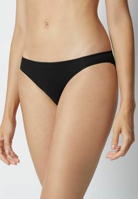 Czarne majtki bikini o niskim stanie. Wykonane z gładkiego materiału, z cienkimi elastycznymi krawędziami i bezszwowymi bokami dla minimalistycznego wyglądu.