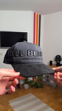 Fekete baseballsapka texturált matt felülettel, a frontoldalon kiemelkedő "ALL BLACK" felirattal és "ORIGIN NY 1975" felirattal.