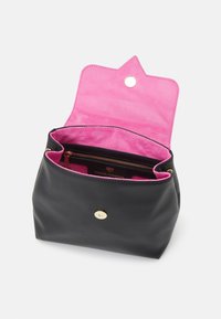 Bolso de cuero negro con un interior de gamuza rosa; cuenta con un cierre a presión, hardware dorado y un bolsillo con cremallera en el interior.