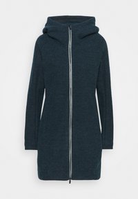 Kapucňový kabát z tmavomodrého materiálu, ktorý má predný zips a dlhé rukávy. Hladká textúra s priliehavým strihom a akcentovaným šitím.