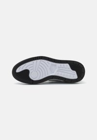 Black and white sneaker sole with textured pattern. Features a prominent circular design and horizontal lines for grip. Made of rubber material.