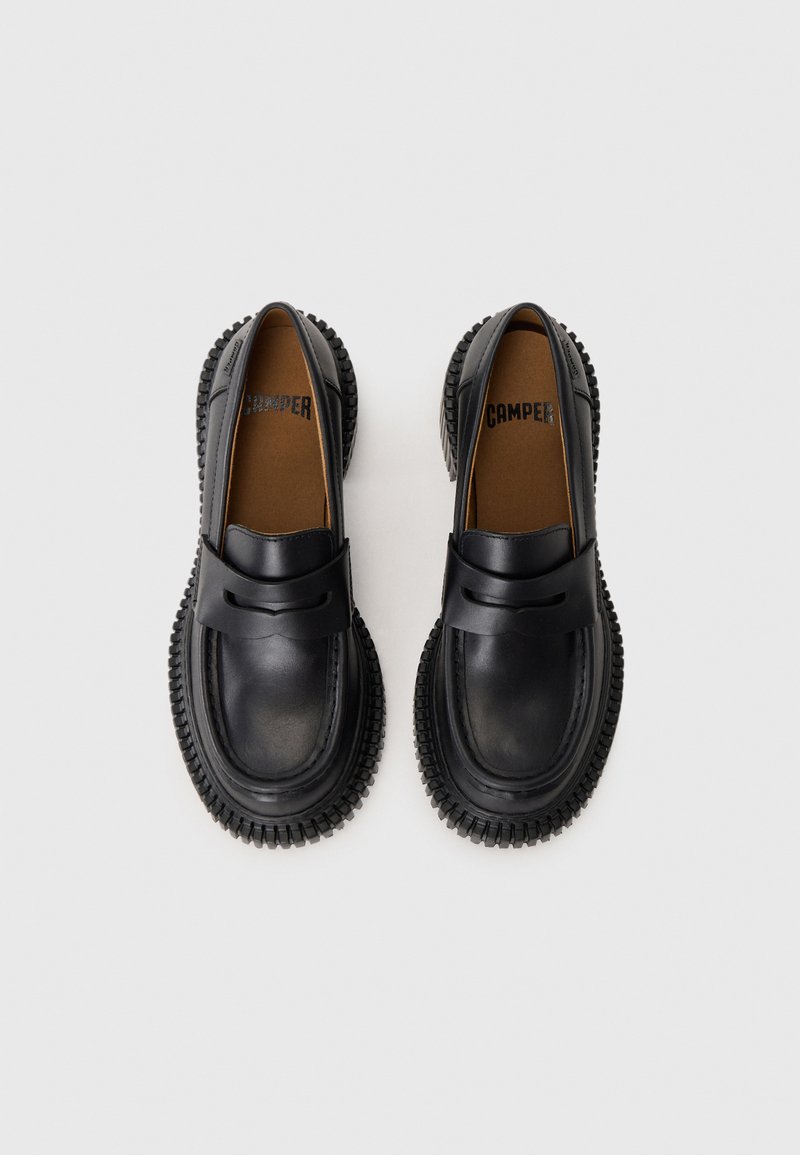 Sort læder loafers med en tekstureret gummisål, der har en glat overdel og et minimalt stropdetalje over foden.
