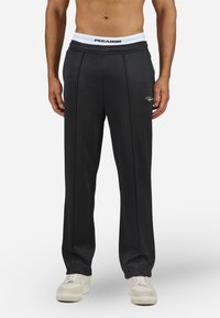 Black athletic trousers with a white elastic waistband, featuring a logo and vertical seam details. Made from a soft, lightweight fabric.