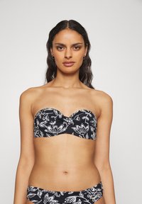 Juodai baltas gėlių bandeau tipo bikini viršus su struktūruotais puodeliais, su posūkiu priekyje ir lygiu audinio tekstūromis.