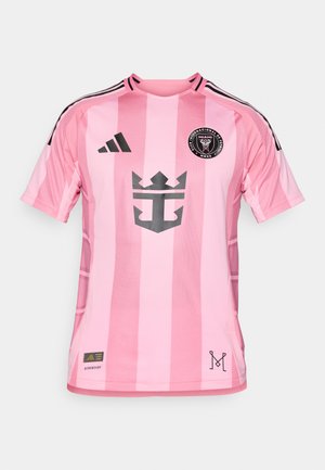 Maglietta da calcio rosa con strisce verticali, colletto a girocollo nero ed emblema sul petto. Realizzata in tessuto traspirante con design leggero.