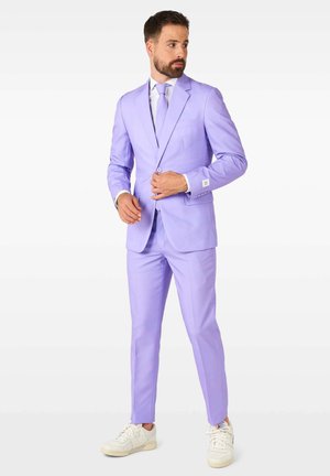 Completo viola chiaro con design slim-fit, chiusura a un bottone e rever a punta. Abbinato a una cravatta chiara e scarpe da ginnastica bianche.