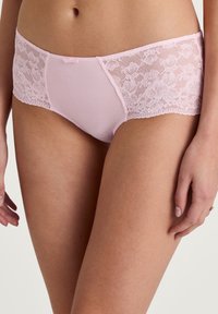 Lichtroze slipjes met een effen voorkant en kanten zijpanelen met bloemmotief, afgewerkt met een delicate kantafwerking en een klein strikje.