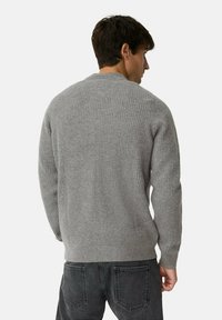 Grauer gerippter Strickpullover mit langen Ärmeln und rundem Ausschnitt, der von hinten gesehen eine strukturierte Stoffoberfläche und eine lockere Passform zeigt.