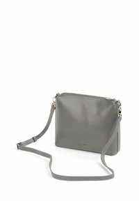 Šedá kožená crossbody taška s hladkým povrchem, obdélníkovým tvarem, zipovým uzávěrem a nastavitelným popruhem. Obsahuje decentní kovové detaily.