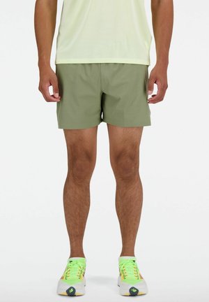 Grüne Sportshorts aus leichtem Material mit strukturiertem Muster, knielang und einem elastischen Bund für hohen Tragekomfort.