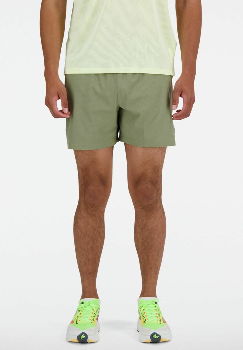 Grüne Sportshorts aus leichtem Material mit strukturiertem Muster, knielang und einem elastischen Bund für hohen Tragekomfort.