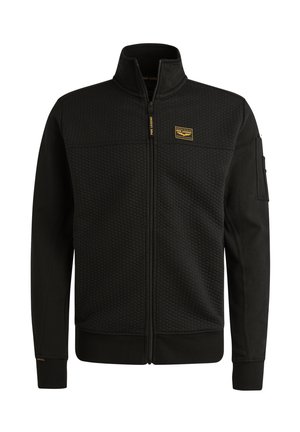 Veste noire zippée avec une partie supérieure texturée, une partie inférieure lisse, un col montant et un petit logo jaune sur la poitrine. Elle dispose de poches latérales.