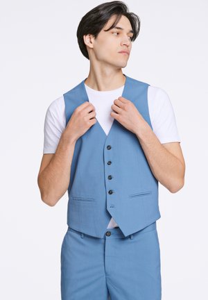Gilet bleu clair avec un motif texturé, doté d'un col en V, de six boutons noirs et de deux poches avant, porté sur une chemise blanche.