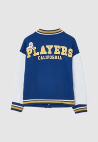 Niebiesko-biała kurtka z żółtym napisem. Napis "PLAYERS CALIFORNIA." Z grafiką lwa oraz prążkowanym, żebrowanym kołnierzem i mankietami.