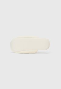 Sandal cu toc plat de culoare crem, cu o parte superioară moale, căptușită și v�ârf rotund. Design minimalist, construcție fără cusături și talpă plată.