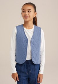 Vadderad blå väst med ärmlös design, rundad halsringning och strukturerat diamantsmönster, bärs över en vit långärmad skjorta och blå byxor.