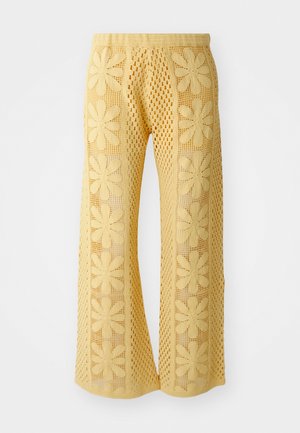 Gelbe Häkelhosen mit floralem Muster, weit geschnitten, und einem elastischen Bund mit einem strukturierten, offen gearbeiteten Design.