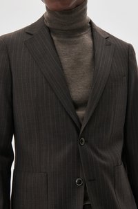 Donkergestreepte blazer met notched lapels en twee knopen, gecombineerd met een geribbelde bruine coltrui. Gladde stoftextuur.