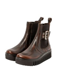 Botas de cuero marrón hasta el tobillo con paneles elásticos en los lados, suela negra gruesa y un ribete plateado en el costado. Textura suave, punta redondeada.