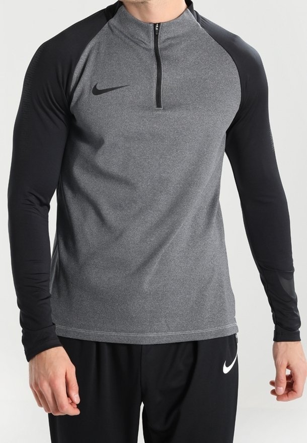 Camiseta de manga larga de Nike con diseño de media cremallera. Cuerpo gris con mangas negras, tejido texturizado y un pequeño logo en el pecho.