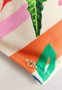 Värvikas kangas abstraktsete mustritega roosas, rohelises ja oranžis. Omab kuldset aktsenti ja servas siksak-õmblusi. Sile tekstuur.