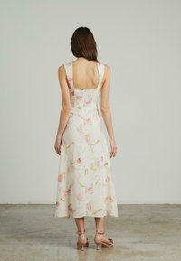 Blumenleinenkleid mit quadratischem Rücken, das mit pastellrosa Blumenmustern verziert ist, einem taillierten Oberteil und einem fließenden A-Linie-Rock.
